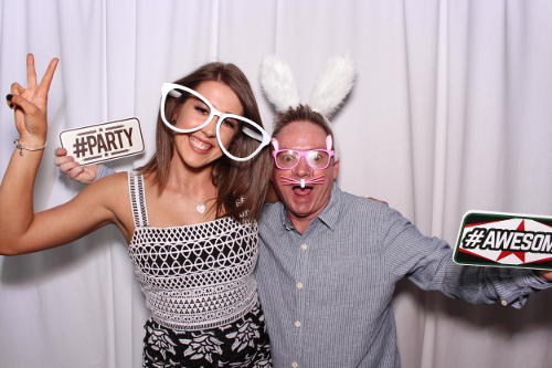 Two people posing for a photobooth in Adelaide with a white backdrop